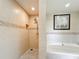 Bathroom with a glass-enclosed shower featuring tiled walls and recessed shelf at 7593 Gathering Dr # 203, Reunion, FL 34747