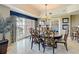 Elegant dining room featuring a chandelier, dining table, and access to an outdoor balcony overlooking water at 7593 Gathering Dr # 203, Reunion, FL 34747