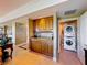 A convenient wet bar is positioned near a doorway that reveals a laundry room with stacked washer and dryer units at 7593 Gathering Dr # 203, Reunion, FL 34747