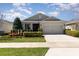 Charming single-story home with a well-manicured lawn, lush landscaping, and a two-car garage at 7838 Penrose Pl, Wildwood, FL 34785
