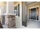 Inviting covered front porch with stone accents and a screened entryway, providing a shaded entrance at 7838 Penrose Pl, Wildwood, FL 34785