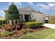 Landscaped front yard featuring colorful flowers and manicured shrubs enhancing the curb appeal of this home at 7838 Penrose Pl, Wildwood, FL 34785