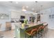 Beautiful kitchen boasts granite countertops, stainless steel appliances and island with bar stool seating at 7838 Penrose Pl, Wildwood, FL 34785