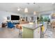 Open-concept kitchen with granite countertops, stainless steel appliances, and bar stool seating is adjacent to the living room at 7838 Penrose Pl, Wildwood, FL 34785