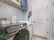Functional laundry room with front-load washer and dryer, storage shelves, and ample counter space at 7838 Penrose Pl, Wildwood, FL 34785