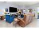 Spacious living room featuring stylish seating, a large screen TV, and decorative shelving, ideal for relaxation at 7838 Penrose Pl, Wildwood, FL 34785