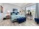 Comfortable main bedroom features a tray ceiling, stylish decor, and a large window overlooking the backyard at 7838 Penrose Pl, Wildwood, FL 34785