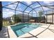 Beautiful screened pool area features a plunge pool with a relaxing waterfall feature at 7838 Penrose Pl, Wildwood, FL 34785