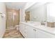 Elegant bathroom featuring double sinks, quartz countertop, and glass enclosed shower at 8199 Coconut Pl, Kissimmee, FL 34747