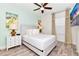 Bright bedroom featuring a ceiling fan, a queen bed, and matching nightstands with unique lamps at 8199 Coconut Pl, Kissimmee, FL 34747