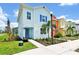 Charming, colorful two-story home with landscaped front yard and walkway at 8199 Coconut Pl, Kissimmee, FL 34747