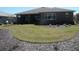 Landscaped backyard featuring a well-maintained lawn, mulch beds, and a covered lanai at 8824 Sw 104Th Cir, Ocala, FL 34481