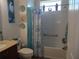 Bright bathroom featuring a tub with shower, white tile, and ocean-themed decorations at 8824 Sw 104Th Cir, Ocala, FL 34481