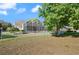 The backyard features a screened-in pool area, fenced yard, and mature tree offering privacy at 437 Wilmington Cir, Oviedo, FL 32765