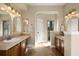 Bathroom with double sinks, vanity, mirrors, tile floor, and walk-in shower with glass door at 437 Wilmington Cir, Oviedo, FL 32765