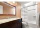 Well lit bathroom with a shower and bathtub combo, skylight, granite countertops, and dark wood cabinets at 437 Wilmington Cir, Oviedo, FL 32765