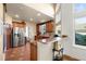Bright kitchen featuring bar, terracotta-colored tile flooring, and stainless steel refrigerator at 437 Wilmington Cir, Oviedo, FL 32765