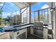 Enclosed patio area featuring an outdoor kitchen with a grill and stainless steel appliances at 437 Wilmington Cir, Oviedo, FL 32765