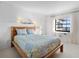 Bedroom with natural light, a wooden bed frame, and a cozy blue and green quilt at 100 S Interlachen Ave # 503, Winter Park, FL 32789