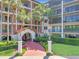 Inviting condo building entrance with lush landscaping, featuring a red walkway to the double door entry at 100 S Interlachen Ave # 503, Winter Park, FL 32789