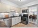 Bright kitchen with stainless steel appliances, tile flooring, and a view into the dining and living area at 100 S Interlachen Ave # 503, Winter Park, FL 32789