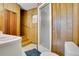 Bathroom features wood paneling, walk-in shower, toilet, sink, and tiled flooring at 1120 Sheeler Ave, Apopka, FL 32703