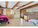 Large bedroom featuring brick accent wall, exposed beam ceiling, and tile flooring at 1120 Sheeler Ave, Apopka, FL 32703
