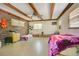 Spacious bedroom featuring exposed wood beams, brick accent wall, and tile flooring at 1120 Sheeler Ave, Apopka, FL 32703