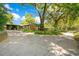 Long driveway leading to a home with mature trees and a side carport in a serene setting at 1120 Sheeler Ave, Apopka, FL 32703