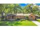 Charming single-story brick home with a well-manicured lawn and mature trees in a peaceful residential neighborhood at 1120 Sheeler Ave, Apopka, FL 32703