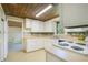 Bright kitchen featuring white cabinets, laminate countertops, and light wood-look flooring at 1120 Sheeler Ave, Apopka, FL 32703