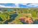 Aerial view of a baseball field and lush greenery under a partly cloudy sky near a lake at 122 Spreading Oak Ct, Sanford, FL 32773