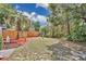 A large backyard with a new wooden fence is tastefully landscaped with rocks and palm trees at 122 Spreading Oak Ct, Sanford, FL 32773