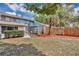 A backyard with a screened-in porch, lush plants, stone decorations, and a fence at 122 Spreading Oak Ct, Sanford, FL 32773