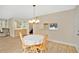 Comfortable dining area featuring bright light fixture and a mirrored passthrough to kitchen at 122 Spreading Oak Ct, Sanford, FL 32773