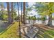 Outdoor picnic area with a decorative table and seating overlooking a tranquil lake surrounded by trees on a sunny day at 122 Spreading Oak Ct, Sanford, FL 32773