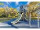 Community playground featuring a large slide and climbing structure with safety surfacing, set among trees on a sunny day at 122 Spreading Oak Ct, Sanford, FL 32773