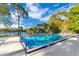 Outdoor swimming pool with blue trim surrounded by lawn chairs and views of a lake and trees under a sunny sky at 122 Spreading Oak Ct, Sanford, FL 32773