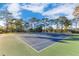 Outdoor tennis court on a sunny day with trees in the background at 122 Spreading Oak Ct, Sanford, FL 32773