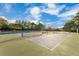 Multiple outdoor tennis and pickleball courts under a blue, partly cloudy sky, and surrounded by trees at 122 Spreading Oak Ct, Sanford, FL 32773