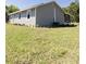 An exterior view of a home with gray siding, white trim, and an expansive lawn at 1350 Martin Luther King Jr Blvd, Bartow, FL 33830