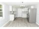 Bright, remodeled kitchen featuring white cabinets, stainless steel appliances, and contemporary gray wood flooring at 1350 Martin Luther King Jr Blvd, Bartow, FL 33830