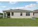 Home's backyard showcasing a well-maintained lawn, a patio, and the exterior of the house at 1355 Wood Line Loop, Deland, FL 32720