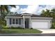 Beautiful single-Gathering home featuring a two-car garage, well-maintained lawn, and classic architectural details at 1355 Wood Line Loop, Deland, FL 32720