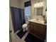 Cozy bathroom featuring a vanity, mirror, blinds, and a shower with a blue shower curtain at 14641 Henson Rd, Orlando, FL 32832