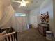 Bedroom with a crib, curtains, changing table, closet, and ceiling fan at 14641 Henson Rd, Orlando, FL 32832