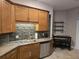 Functional kitchen with wooden cabinets, mosaic backsplash, stainless steel appliances, and a breakfast nook at 14641 Henson Rd, Orlando, FL 32832