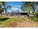 Inviting backyard with a large screened-in patio, fire pit area, and mature trees, perfect for outdoor enjoyment at 1510 Chatsworth Ave, Deltona, FL 32738