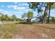 Cozy home exterior with a large front yard, mature trees, and a glimpse of the house's side and roof at 1510 Chatsworth Ave, Deltona, FL 32738