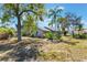 A view of the home's exterior showing a well-kept lawn, chain-link fence and mature trees at 1510 Chatsworth Ave, Deltona, FL 32738